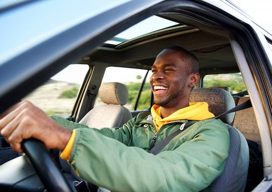 Smiling man with green jacket driving
