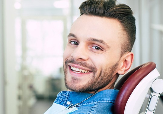 Patient smiling while sitting in treatment chair