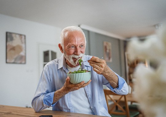 Man smiling while eating lunch at home