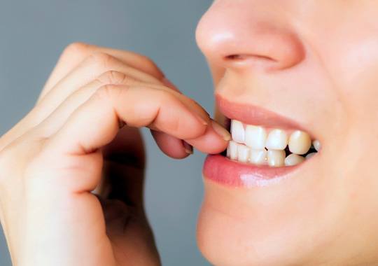 Closeup of patient biting their nails