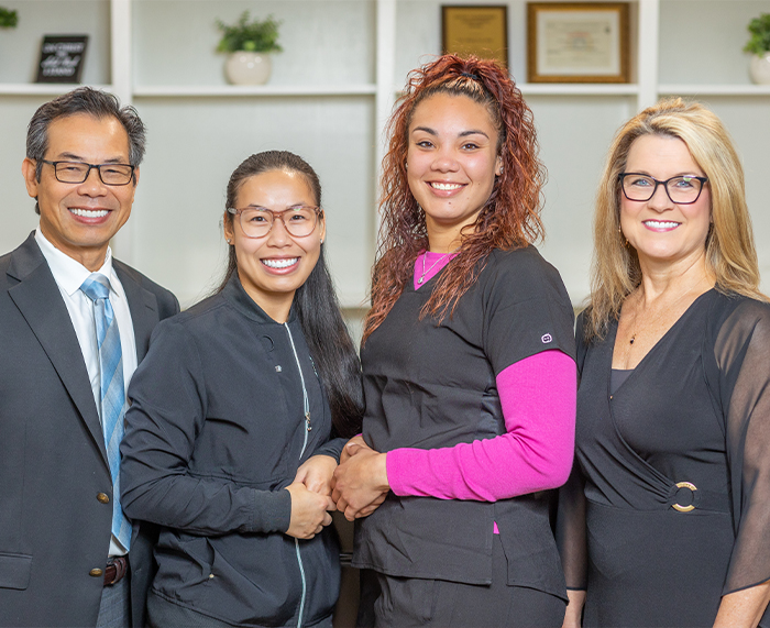 Doctor Lim and three smiling Owasso dental team members