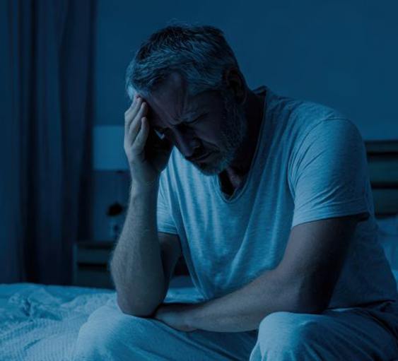 Man with anxiety sitting on his bed