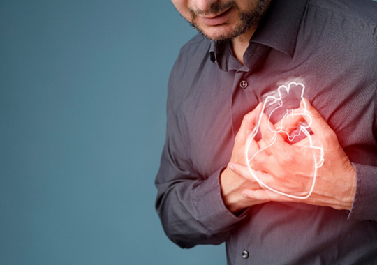 Man in gray shirt clutching his heart