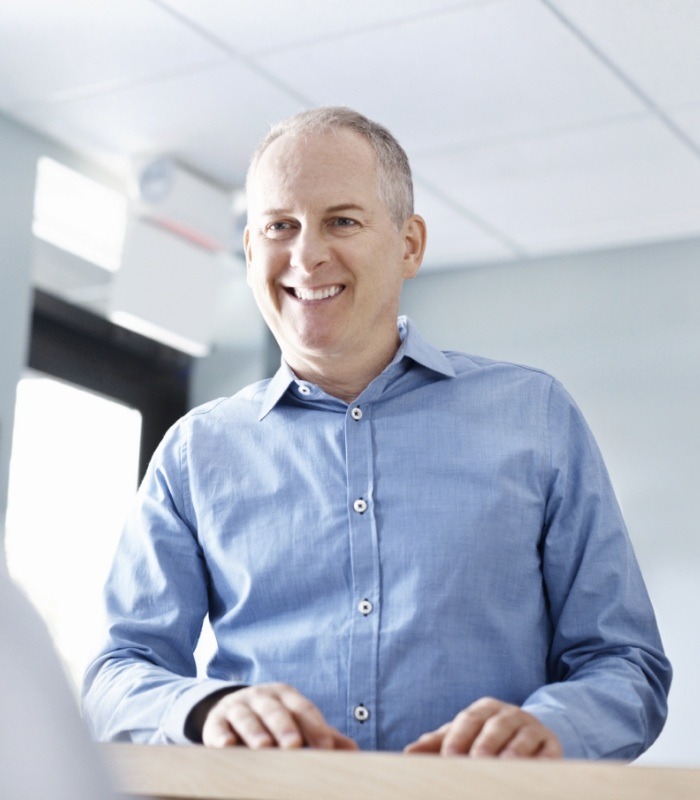 Man smiling at dental office receptionist