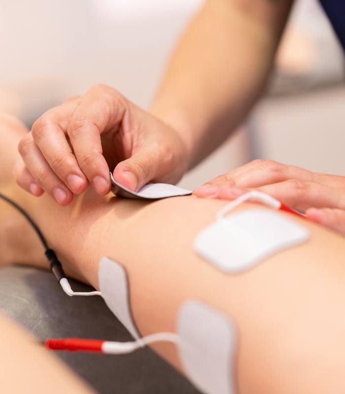 Person placing electrodes on arm of another person