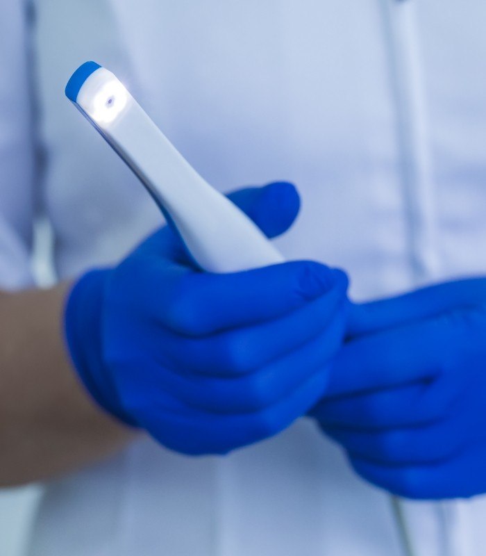 Dental team member holding an intraoral camera