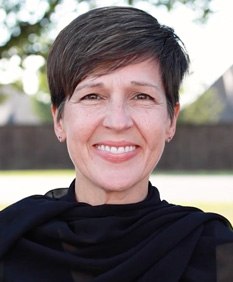 Woman with short hair smiling outdoors