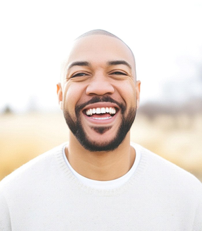 Man in white shirt smiling outside