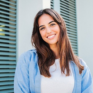 Woman with white teeth smiling while standing outside