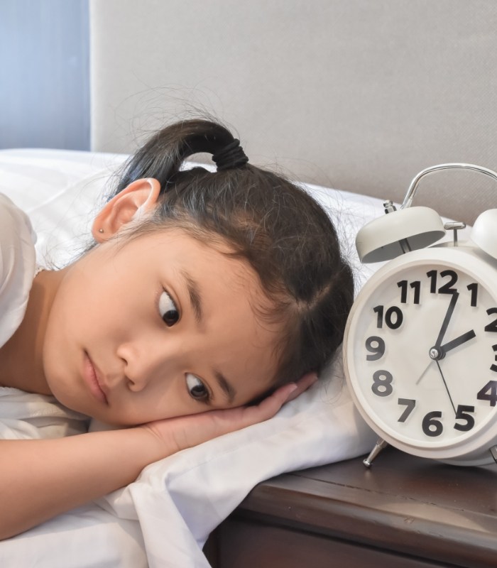 Young girl laying awake in bed