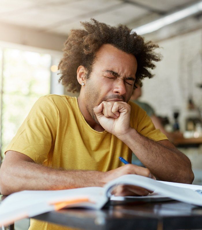 Man yawning while sitting at desk