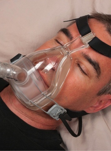 Sleeping man wearing a C P A P mask