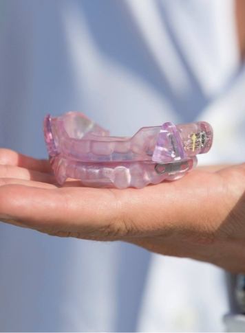 Dentist holding a light purple oral appliance