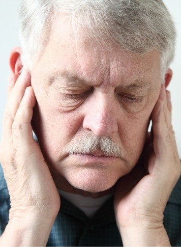 Older man holding his temples in pain