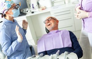 Happy patient interacting with dental team members